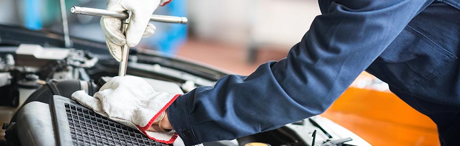 Close up of a mechanic working under the bonnet of a car