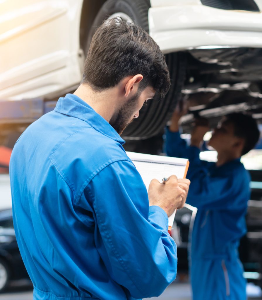 Mechanic looking over a vehicle service checklist - MOT & Garage Services Plymouth