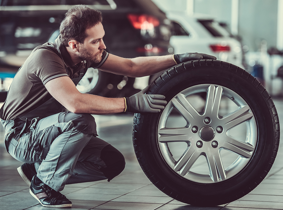 Mechanic inspecting a vehicle tyre - Tyres Plymouth